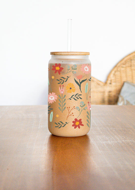 A glass cup with colorful flowers and twigs